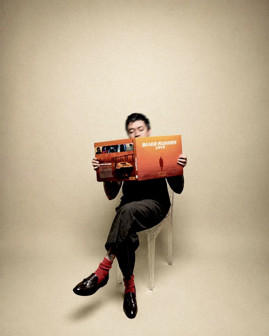 Lalo seated, reading a Blade Runner 2049 art book