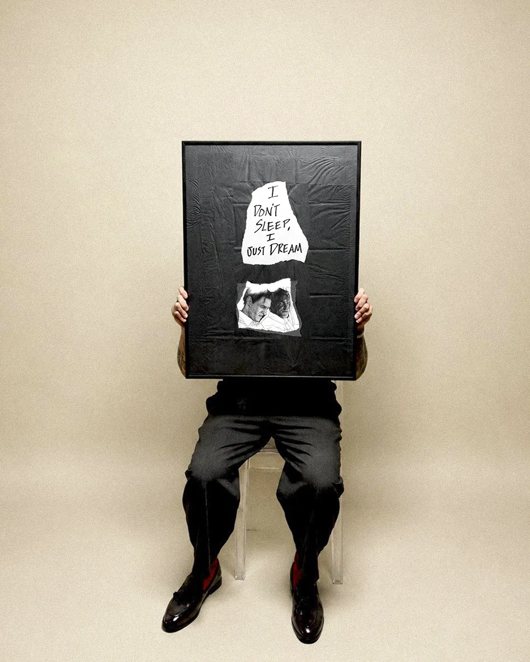 Lalo holding a framed illustration that reads I don't sleep, I just dream