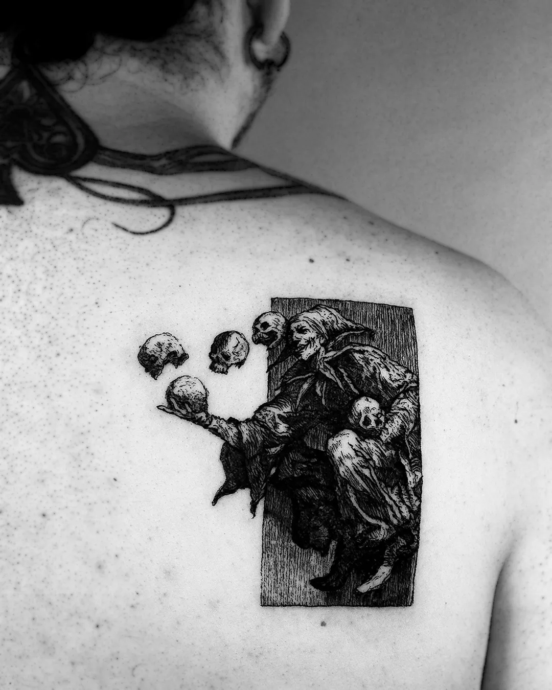 Woodcut back piece of a hooded jester holding a skull