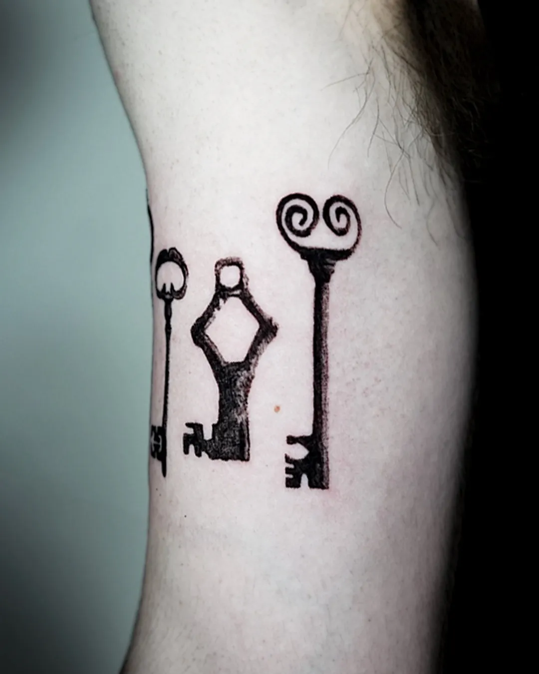 Three antique keys drawn in clean black line on the inner arm