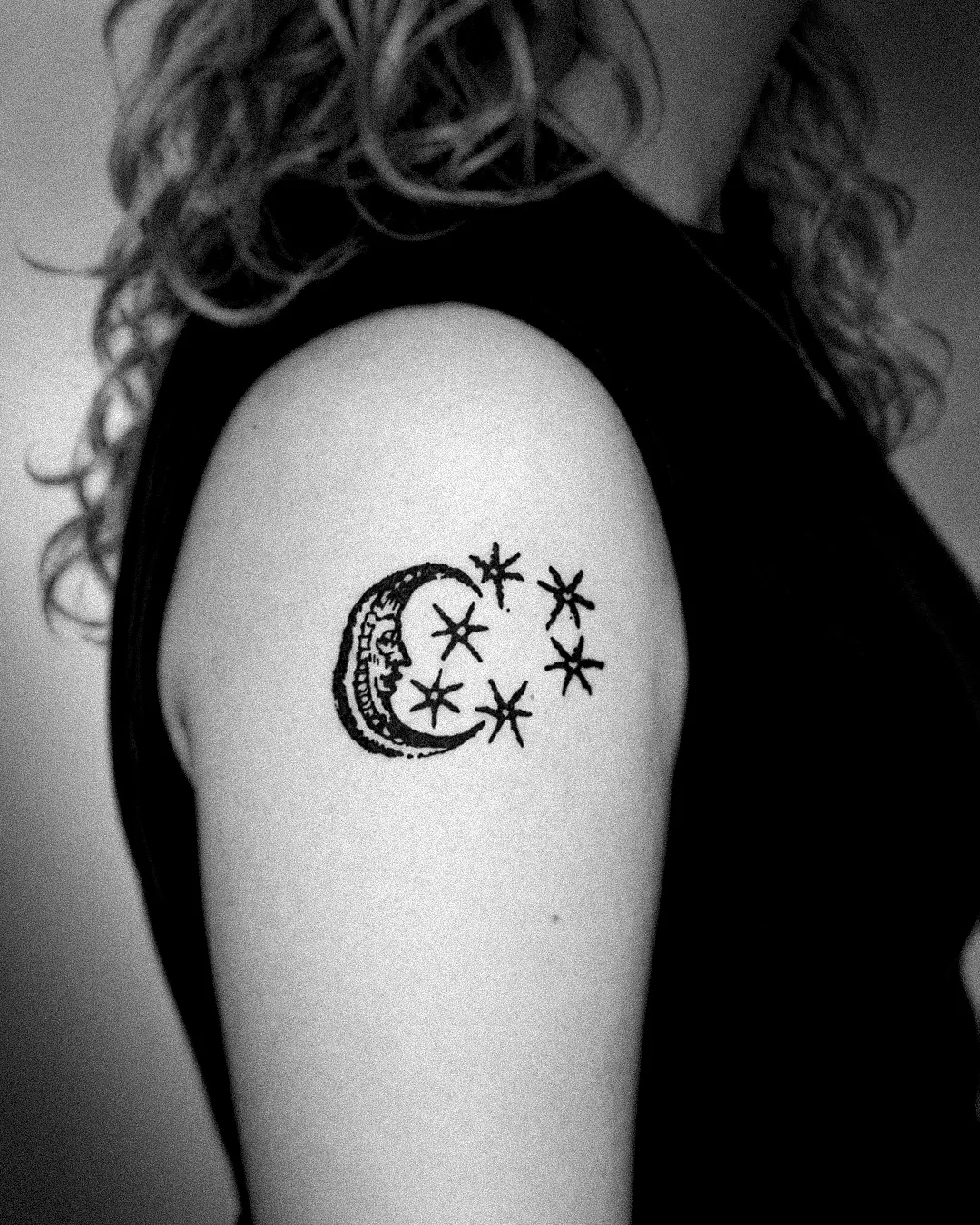 The moon and stars woodcut tattoo on the shoulder